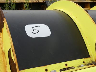 a close up of a black and yellow trash can with a number 5 on it