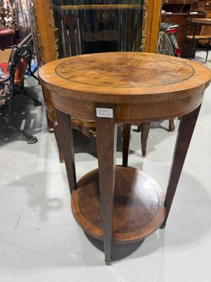 une petite table ronde avec un plateau en bois dans un magasin