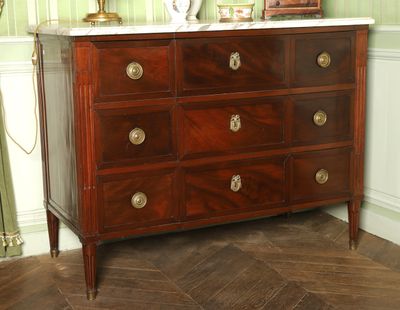 a dresser with a marble top in the corner of a room