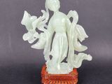 an image of a statue of a woman holding flowers on top of a table