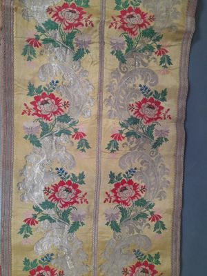 un vieux chemin de table jaune et rouge orné de motifs floraux