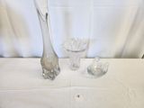 three glass vases and a spoon on a table