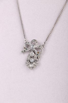 Collier plaqué argent orné d'un nœud et de cristaux sur fond blanc
