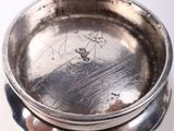 a silver plate with a silver lid sitting on a table