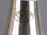 a silver vase with a white lid on a table