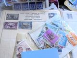 une pile de timbres posée sur une table, sur laquelle se trouve une feuille de papier