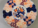 une assiette orange et bleue décorée de fleurs, posée sur une table