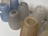 many different colored vases sitting on a white surface