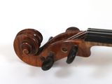 an old violin sitting on top of a white table next to a white wall