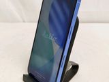 a close up of a cell phone on a stand on a white surface