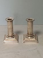 Paire de bougeoirs en métal argenté de style Louis XVI à bas…