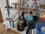 a kitchen counter with a tea kettle and a cutting board on it