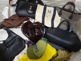 a lot of purses and hats sitting on a bed