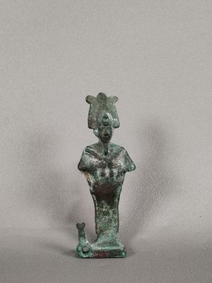 une ancienne statue en bronze représentant une femme avec un chat assis sur ses genoux