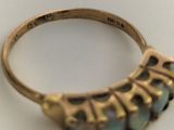 a gold ring with blue stones in it on a table