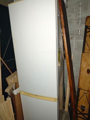 a white refrigerator in the middle of a pile of wood