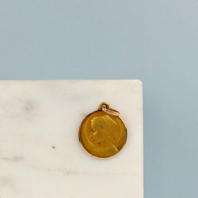 un gros plan d'une pièce d'or posée sur un bloc de marbre blanc