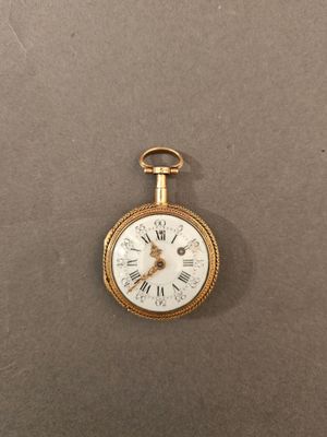 Gros plan sur une montre de poche en or avec des chiffres romains