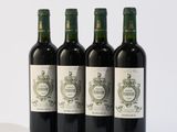 quatre bouteilles de vin sont alignées sur une surface blanche