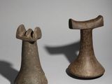 two pieces of pottery sitting next to each other on a white surface