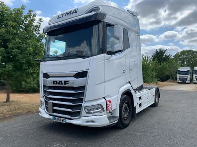 un camion blanc garé sur le bord de la route