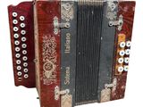 an image of a red and black accordion sitting on top of a white surface