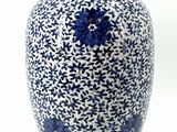 a blue and white vase sitting on a white surface