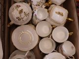a box full of tea cups and saucers sitting on the floor