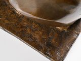 a bronze sculpture of a bowl sitting on top of a table