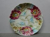 une assiette décorative ornée de fleurs, posée sur une table