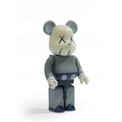 une peluche représentant un ours gris et noir avec un museau noir