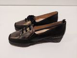 pair of black leather shoes with laces on them on a white surface