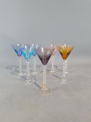 quatre verres à vin de couleurs différentes alignés en rang sur une table