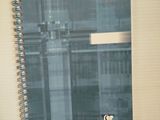 un cahier à spirales avec une couverture bleue posé sur une table