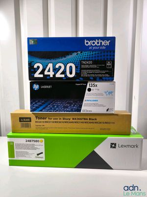 Trois cartouches de toner sont empilées les unes sur les autres sur une table
