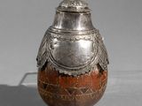 un vieux vase en argent surmonté d'un oiseau