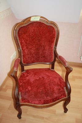 a red chair that is sitting on a wooden floor