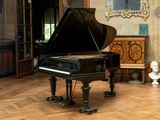 a grand piano sitting in the middle of a living room