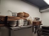 many plates and pans on a shelf in a kitchen