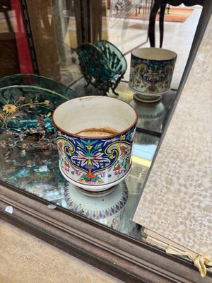 two cups on a glass table in front of a mirror