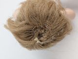 a close up view of a doll ' s hair on a white surface