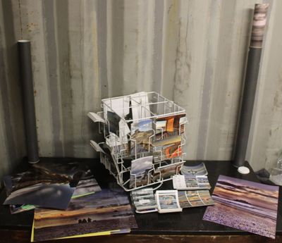 une pile de cartes postales posée sur une table à côté d'une lampe