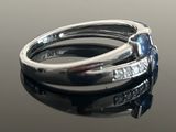 a close up of a ring with a blue stone