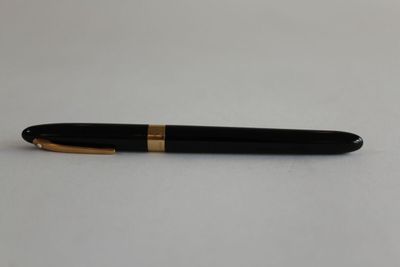 a black and gold pen sitting on top of a white table