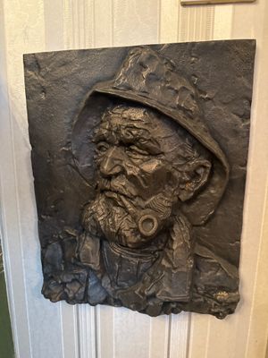 une statue représentant un homme avec une pipe à la bouche
