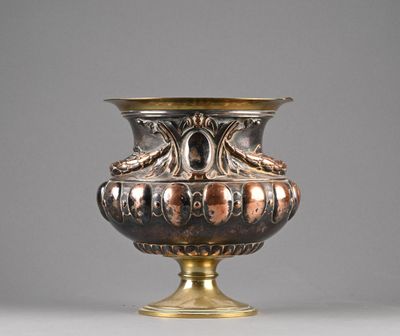 a silver and gold vase sitting on a table
