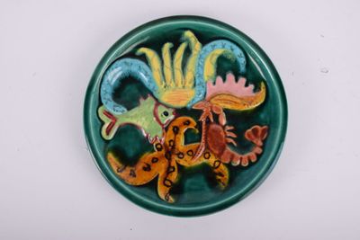a green plate with a picture of a bird and a lizard on it