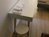 une petite table avec un tabouret dans un coin de la pièce