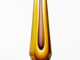 un vase marron et vert posé sur une surface blanche