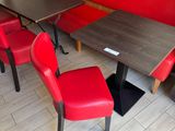 red chairs and a table in a restaurant with wood paneled walls